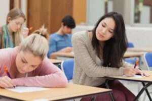 a female blogger is copying from others sitting next to her in the exam