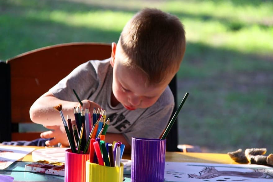 a little boy focusing on his painting which is his passion