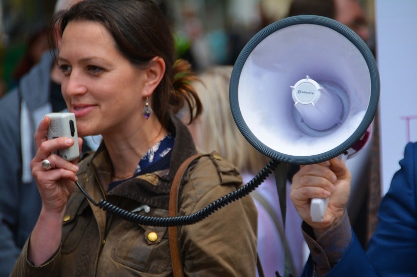 a woman marketer using a megaphone to give speech, calling for action from event participants