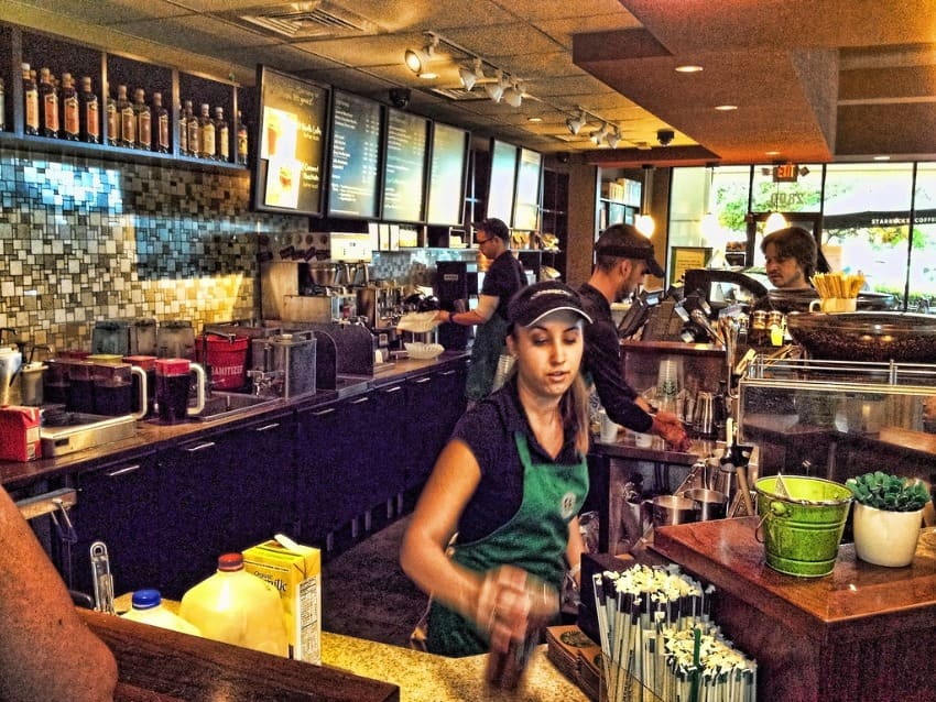 A woman blogger busy with her job full time job working as a barista on day time.